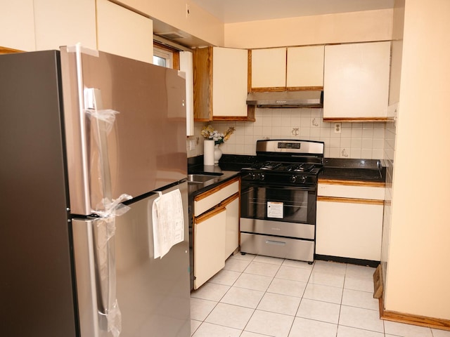 9404 Hamlin Ave, Des Plaines, IL 60016 - kitchen featuring appliances with stainless steel finishes, under cabinet range hood, dark countertops, backsplash, and light tile patterned floors