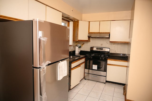 9404 Hamlin Ave, Des Plaines, IL 60016 - kitchen featuring stainless steel appliances, under cabinet range hood, light tile patterned flooring, dark countertops, and decorative backsplash