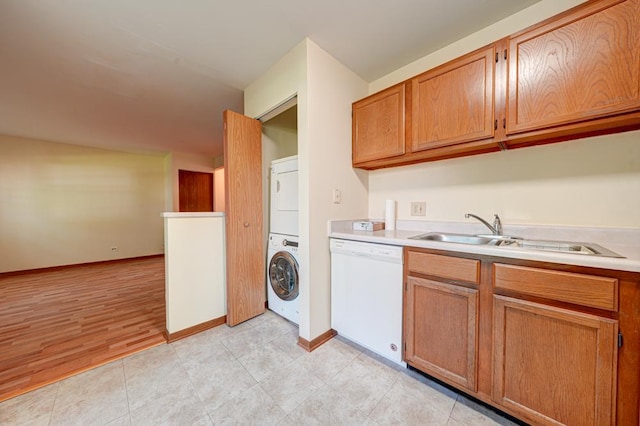 556 E Shagbark Ln Unit C, Streamwood, IL 60107 - kitchen featuring white dishwasher, estacked washer and dryer, light countertops, and brown cabinetry