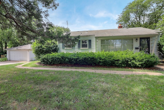 950 Pennsylvania Ave, Aurora, IL 60506 - view of front of house with a garage, a chimney, a front yard, and an outbuilding