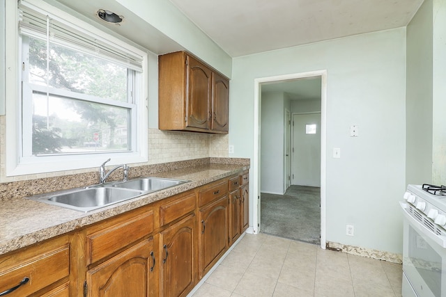 950 Pennsylvania Ave, Aurora, IL 60506 - kitchen with white range with gas stovetop, light tile patterned floors, brown cabinetry, decorative backsplash, and light countertops