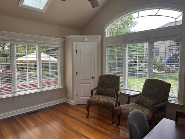 12840 Shenandoah Trl, Plainfield, IL 60585 - sitting room featuring ceiling fan, healthy amount of natural light, wood finished floors, a skylight, and lofted ceiling