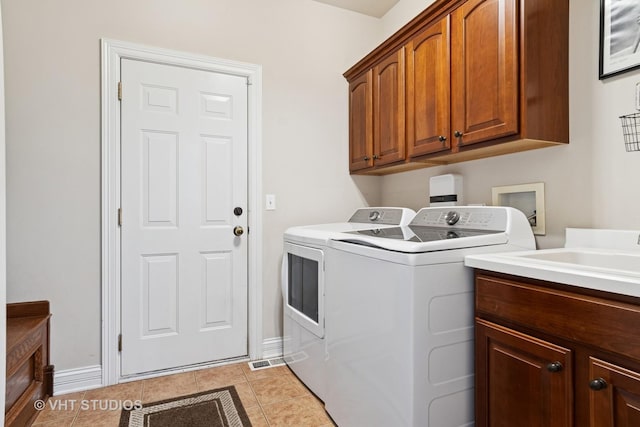 12840 Shenandoah Trl, Plainfield, IL 60585 - laundry room featuring cabinet space, washing machine and clothes dryer, and light tile patterned floors