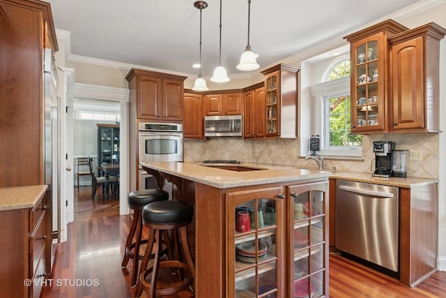 12840 Shenandoah Trl, Plainfield, IL 60585 - kitchen with stainless steel appliances, dark wood-style flooring, brown cabinets, a kitchen bar, and crown molding
