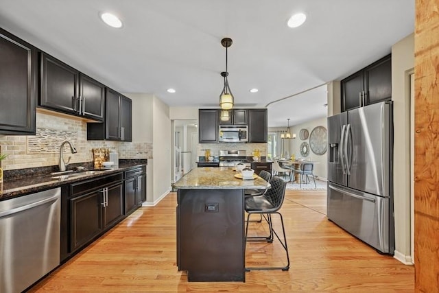 636 N Greenview Ave, Mundelein, IL 60060 - kitchen featuring stainless steel appliances, tasteful backsplash, dark stone counters, a kitchen island, and light wood-type flooring