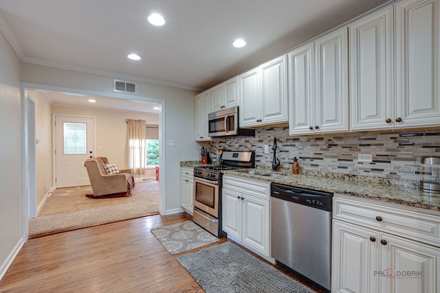 37369 N Loretto Ave, Lake Villa, IL 60046 - kitchen with stainless steel appliances, light wood-style flooring, tasteful backsplash, white cabinets, and ornamental molding
