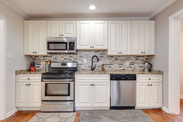 37369 N Loretto Ave, Lake Villa, IL 60046 - kitchen featuring stainless steel appliances, light wood finished floors, decorative backsplash, light stone countertops, and ornamental molding