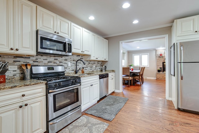 37369 N Loretto Ave, Lake Villa, IL 60046 - kitchen with appliances with stainless steel finishes, crown molding, decorative backsplash, light wood-type flooring, and light stone countertops