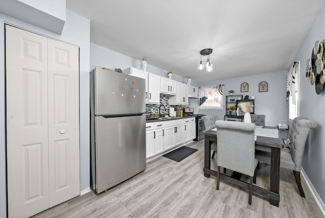 10302 W Palmer Ave, Melrose Park, IL 60164 - kitchen with stainless steel appliances, light wood-style floors, white cabinetry, and dark countertops