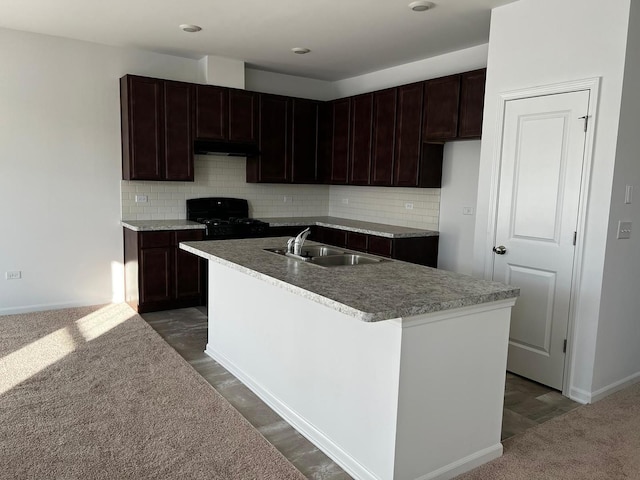 4219 Chelsea Manor Cir, Aurora, IL 60504 - kitchen with stove, under cabinet range hood, backsplash, and an island with sink