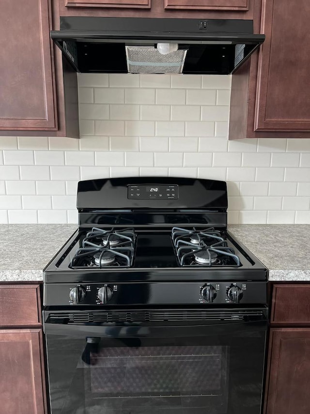 4219 Chelsea Manor Cir, Aurora, IL 60504 - kitchen view of black gas range, range hood, light countertops, and backsplash