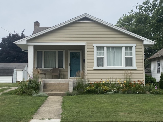 308 S 5th Ave, Streator, IL 61364 - bungalow-style home featuring a chimney, a front yard, and covered porch