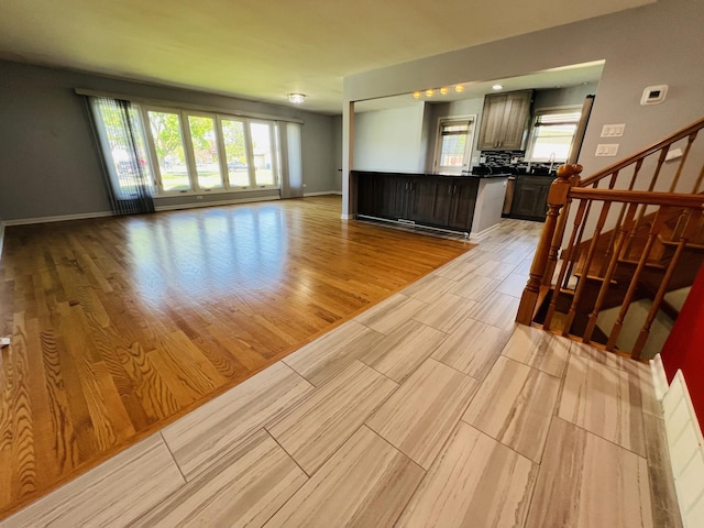 189 Ambleside Rd, Des Plaines, IL 60016 - unfurnished living room featuring healthy amount of natural light, light wood-style flooring, and stairs