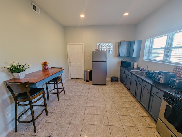 104 W 112th Pl, Chicago, IL 60628 - kitchen featuring stainless steel appliances, dark countertops, recessed lighting, and light tile patterned floors