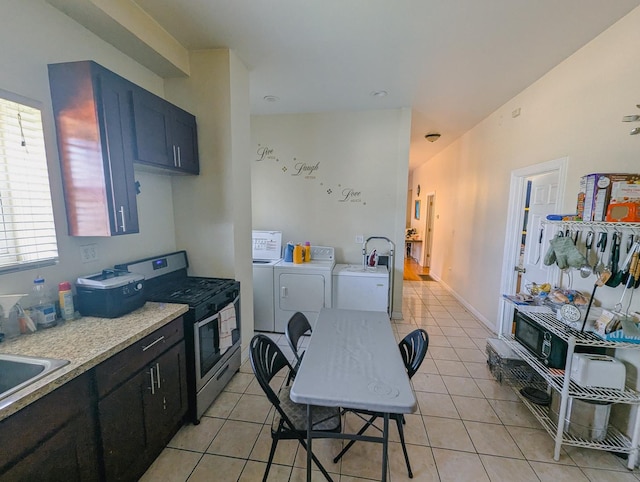 104 W 112th Pl, Chicago, IL 60628 - kitchen featuring stainless steel gas range, independent washer and dryer, light tile patterned floors, and light countertops