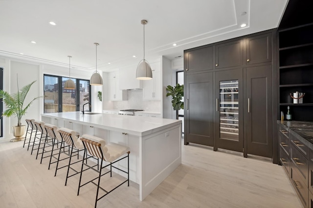 116 N Willard Ct Unit 301, Chicago, IL 60607 - kitchen featuring a spacious island, light wood-style floors, decorative backsplash, a kitchen bar, and recessed lighting