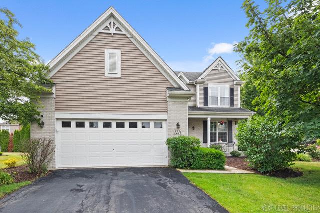 1211 Hall St, Sugar Grove, IL 60554 - traditional-style house featuring driveway, a porch, a garage, and brick siding