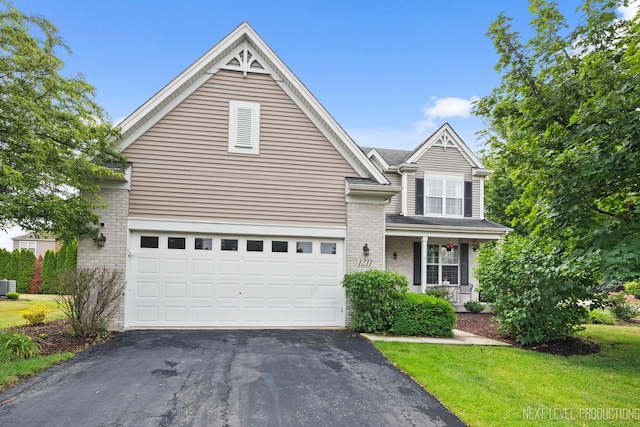1211 Hall St, Sugar Grove, IL 60554 - traditional-style house with driveway, brick siding, a front lawn, a garage, and covered porch