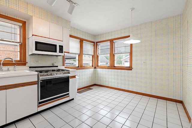 3334 W 114th St, Chicago, IL 60655 - kitchen featuring white microwave, stainless steel range, wallpapered walls, healthy amount of natural light, and light countertops
