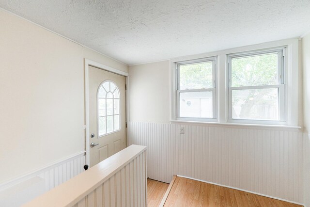 620 Elm St, Maple Park, IL 60151 - corridor with a textured ceiling, a wainscoted wall, and light wood finished floors