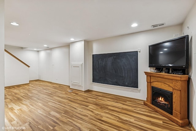 732 Green Castle Ct, West Dundee, IL 60118 - unfurnished living room with wood finished floors, recessed lighting, a warm lit fireplace, and stairs