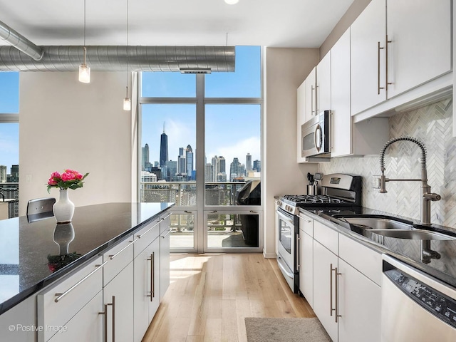 700 N Larrabee St Unit 2008, Chicago, IL 60654 - kitchen with appliances with stainless steel finishes, floor to ceiling windows, light wood finished floors, backsplash, and plenty of natural light