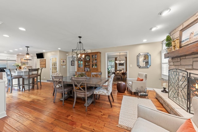 1563 Abbotsford Dr, Naperville, IL 60563 - dining area with light wood-style flooring, recessed lighting, a stone fireplace, and a chandelier