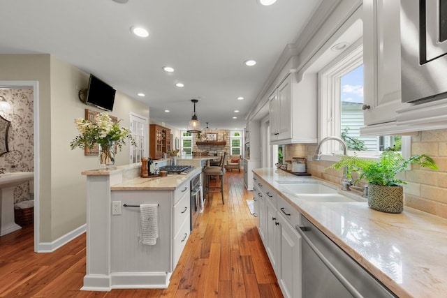 1563 Abbotsford Dr, Naperville, IL 60563 - kitchen with a fireplace, white cabinets, recessed lighting, light wood-style flooring, and a kitchen island
