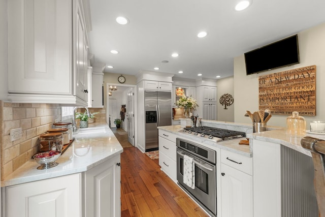 1563 Abbotsford Dr, Naperville, IL 60563 - kitchen featuring appliances with stainless steel finishes, light wood-style floors, white cabinetry, backsplash, and light stone countertops