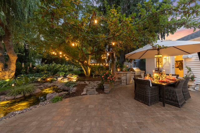 1563 Abbotsford Dr, Naperville, IL 60563 - patio terrace at dusk featuring an outdoor kitchen, a patio, and outdoor dining space