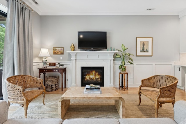 4321 N Paulina St Unit 2N, Chicago, IL 60613 - living room with wood finished floors, a decorative wall, ornamental molding, a premium fireplace, and a wainscoted wall