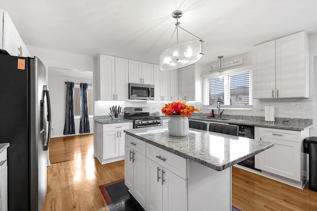 21222 Vivienne Dr, Matteson, IL 60443 - kitchen featuring appliances with stainless steel finishes, tasteful backsplash, a kitchen island, and white cabinets