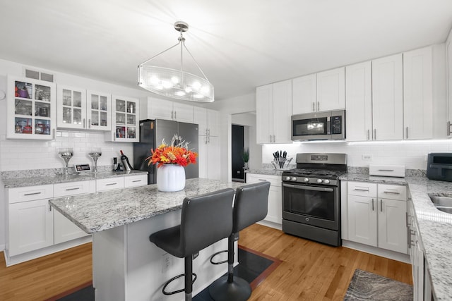 21222 Vivienne Dr, Matteson, IL 60443 - kitchen with appliances with stainless steel finishes, backsplash, a kitchen bar, and a kitchen island