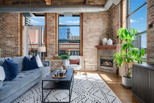 1801 S Michigan Ave Unit 507, Chicago, IL 60616 - living area with brick wall, healthy amount of natural light, wood finished floors, a glass covered fireplace, and radiator heating unit