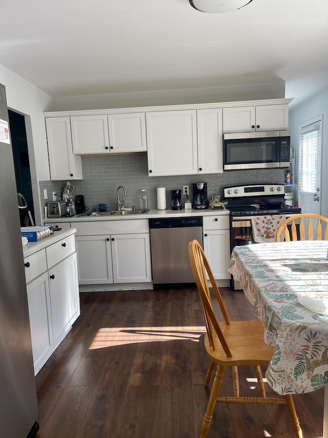 1350 N Elmwood Dr, Aurora, IL 60506 - kitchen featuring appliances with stainless steel finishes, light countertops, decorative backsplash, white cabinets, and dark wood-style flooring