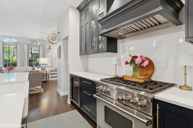 369 W Superior St Unit A, Chicago, IL 60654 - kitchen with custom range hood, high end stainless steel range oven, light countertops, and dark wood finished floors