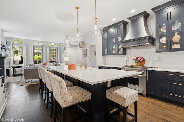 369 W Superior St Unit A, Chicago, IL 60654 - kitchen with high end stove, light countertops, premium range hood, tasteful backsplash, and a kitchen bar
