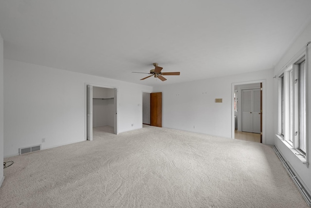 212 Forsythe Ln, Dekalb, IL 60115 - unfurnished bedroom with light carpet, a ceiling fan, a spacious closet, and baseboard heating