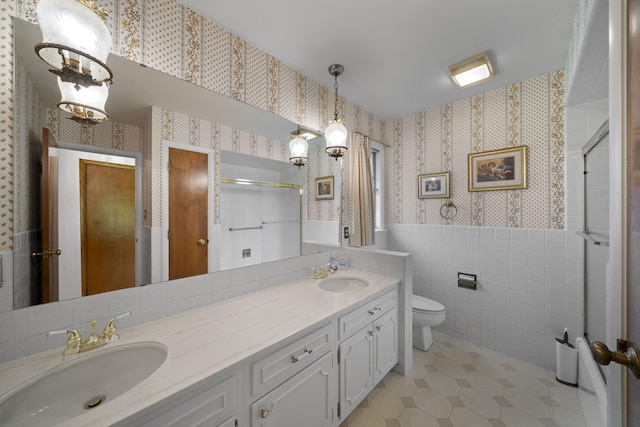 212 Forsythe Ln, Dekalb, IL 60115 - bathroom featuring wallpapered walls, double vanity, tile patterned floors, a wainscoted wall, and tile walls