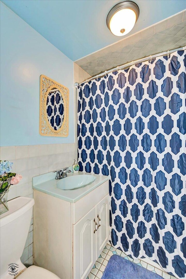 109 Wilson St, Park Forest, IL 60466 - full bathroom featuring vanity, a shower with shower curtain, tile walls, and wainscoting