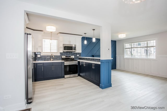 9154 S Luella Ave, Chicago, IL 60617 - kitchen with appliances with stainless steel finishes, light countertops, light wood-type flooring, white cabinets, and wainscoting