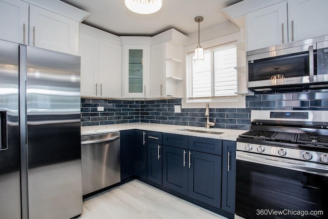 9154 S Luella Ave, Chicago, IL 60617 - kitchen featuring appliances with stainless steel finishes, white cabinets, blue cabinetry, backsplash, and glass insert cabinets