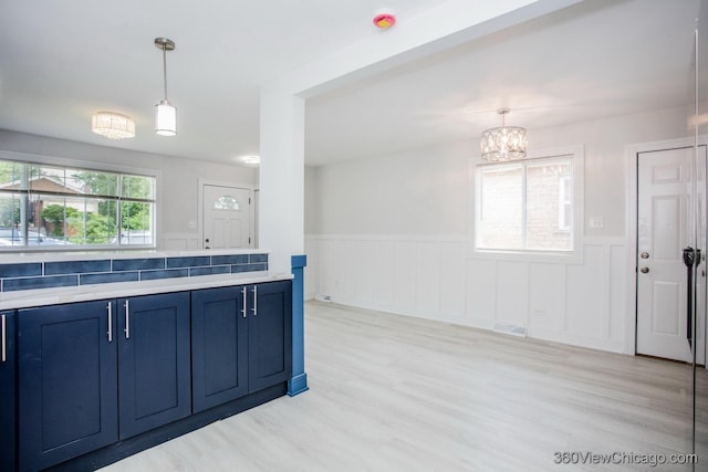 9154 S Luella Ave, Chicago, IL 60617 - kitchen with blue cabinets, wainscoting, a chandelier, light wood-style flooring, and hanging light fixtures
