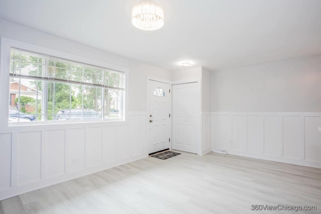 9154 S Luella Ave, Chicago, IL 60617 - foyer featuring a decorative wall, a wainscoted wall, a chandelier, healthy amount of natural light, and wood finished floors