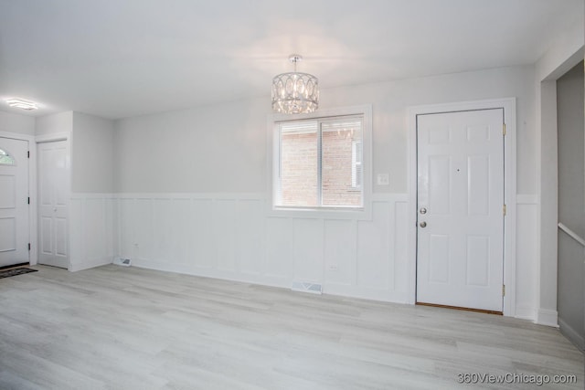 9154 S Luella Ave, Chicago, IL 60617 - entrance foyer with a chandelier, a wainscoted wall, and light wood-style flooring