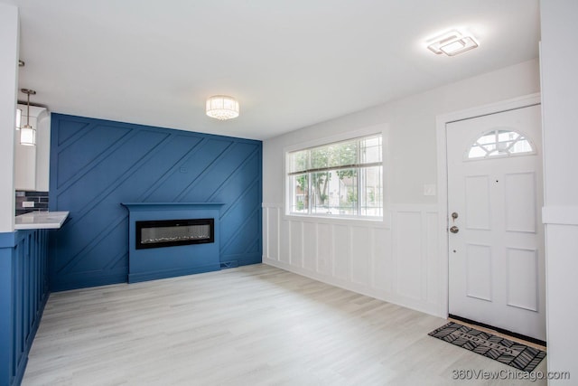 9154 S Luella Ave, Chicago, IL 60617 - entryway featuring a glass covered fireplace, a decorative wall, light wood finished floors, and wainscoting