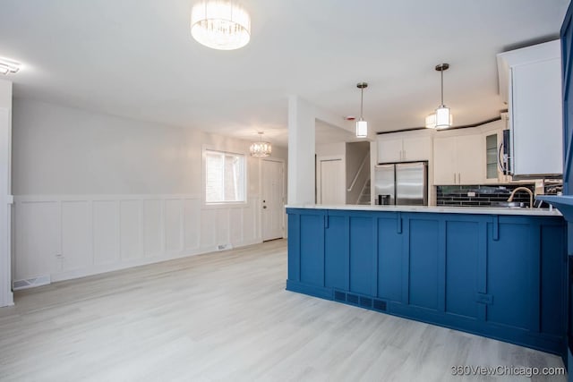 9154 S Luella Ave, Chicago, IL 60617 - kitchen with stainless steel appliances, a chandelier, light wood finished floors, a peninsula, and glass insert cabinets