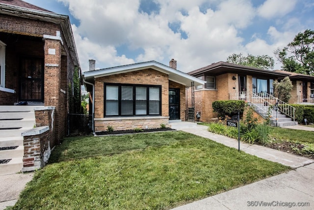 9206 S Yates Blvd, Chicago, IL 60617 - view of front of property featuring a front lawn, brick siding, and a chimney