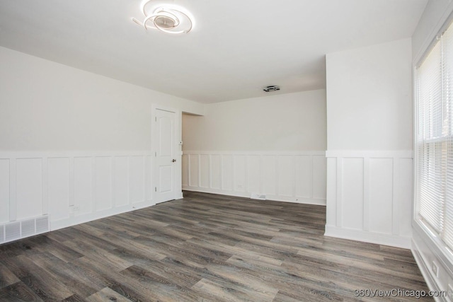 9206 S Yates Blvd, Chicago, IL 60617 - empty room with wainscoting, plenty of natural light, dark wood-style flooring, and a decorative wall