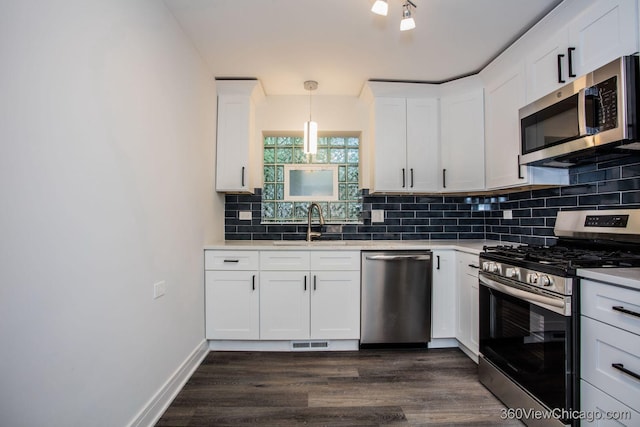 9206 S Yates Blvd, Chicago, IL 60617 - kitchen featuring stainless steel appliances, dark wood-style floors, tasteful backsplash, white cabinetry, and light countertops